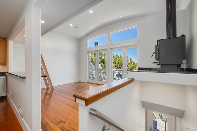 stairs featuring french doors, lofted ceiling, and wood-type flooring