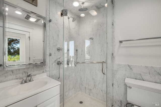 bathroom with a shower with door, tile walls, and toilet