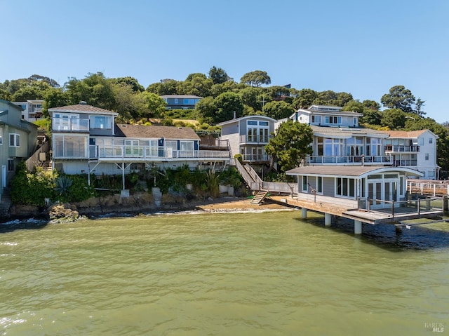 back of property with a water view and a yard