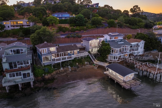 aerial view at dusk featuring a water view