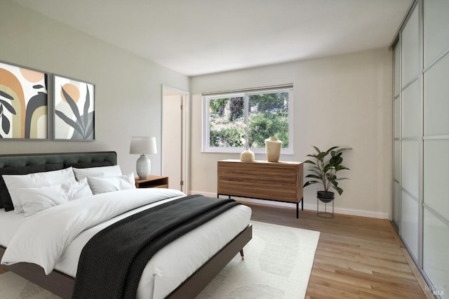 bedroom with light wood finished floors and baseboards