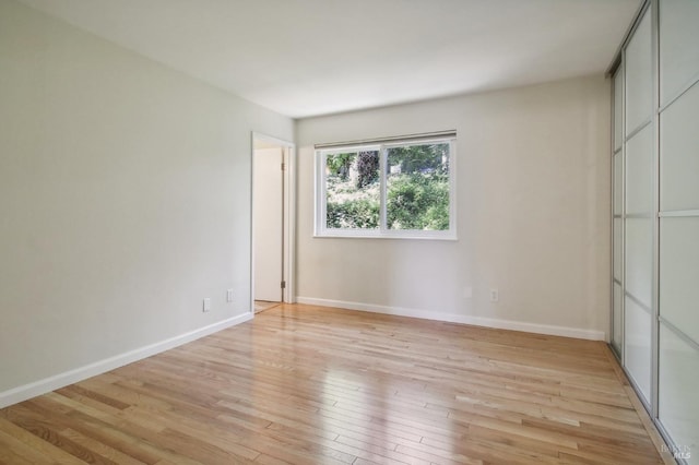 unfurnished bedroom featuring light wood-style flooring and baseboards