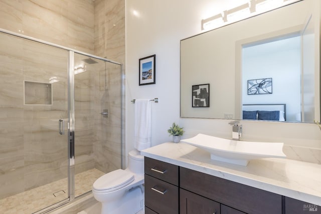 bathroom with a shower with door, vanity, and toilet