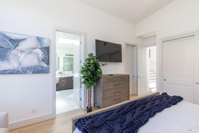 bedroom featuring ensuite bathroom, light hardwood / wood-style flooring, and a closet