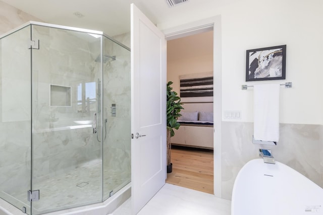 bathroom with hardwood / wood-style floors and an enclosed shower