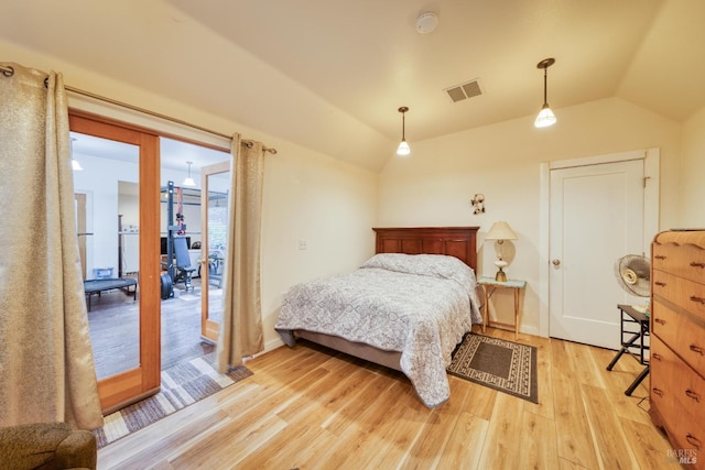 bedroom with light wood-type flooring and vaulted ceiling