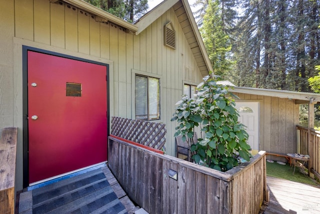 view of exterior entry with a wooden deck