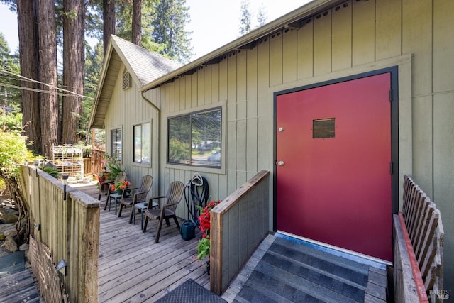 view of exterior entry featuring a wooden deck