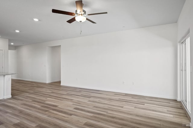 unfurnished living room featuring ceiling fan and light hardwood / wood-style flooring