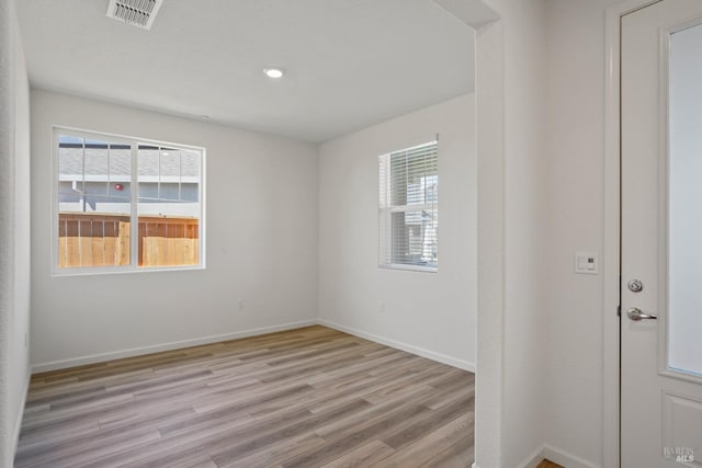 empty room featuring a healthy amount of sunlight and light hardwood / wood-style floors