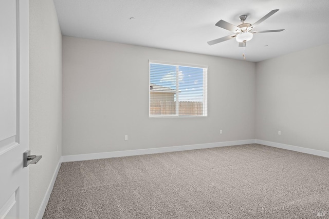 spare room with ceiling fan and carpet