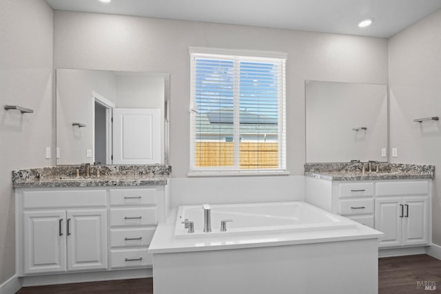 bathroom featuring vanity, a bathing tub, and wood-type flooring