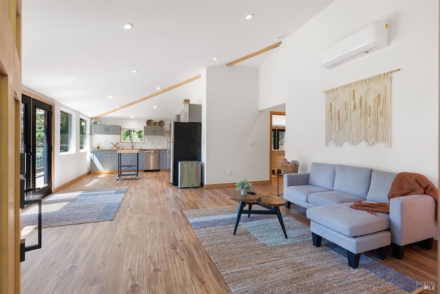 living room featuring sink, vaulted ceiling, a wall mounted AC, and light wood-type flooring