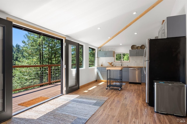 kitchen featuring gray cabinets, sink, decorative backsplash, light hardwood / wood-style floors, and stainless steel appliances