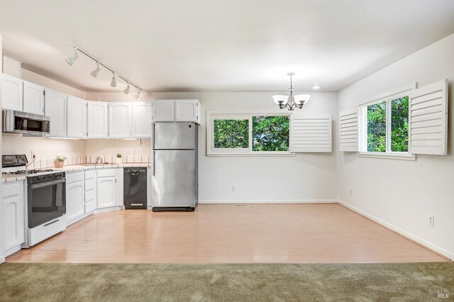 kitchen with white cabinetry, light hardwood / wood-style flooring, stainless steel appliances, and a wealth of natural light