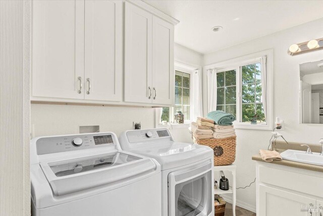 laundry area featuring sink, cabinets, and washing machine and dryer