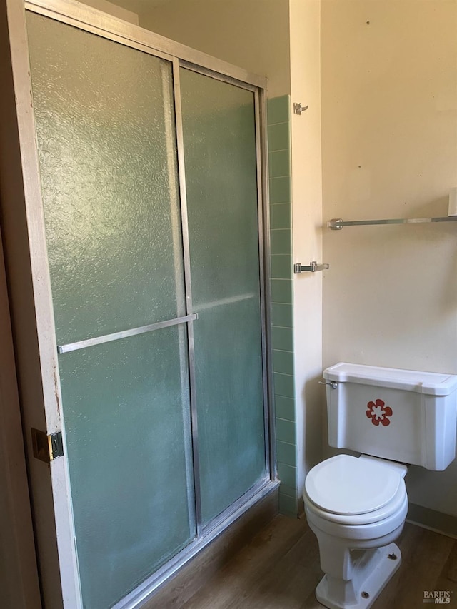 bathroom featuring hardwood / wood-style floors, toilet, and an enclosed shower