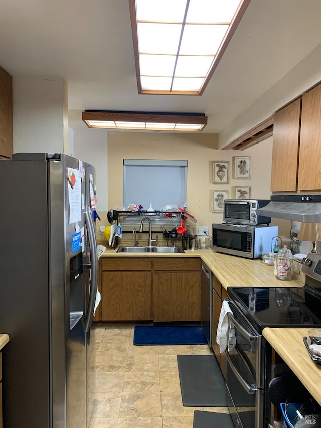 kitchen with exhaust hood, stainless steel appliances, and sink