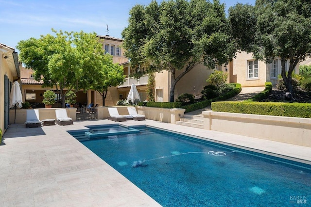 view of swimming pool with an in ground hot tub and a patio