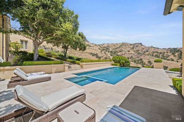 view of pool with a patio and a mountain view