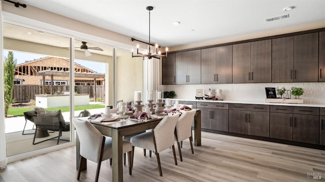 dining room with light hardwood / wood-style floors and a chandelier