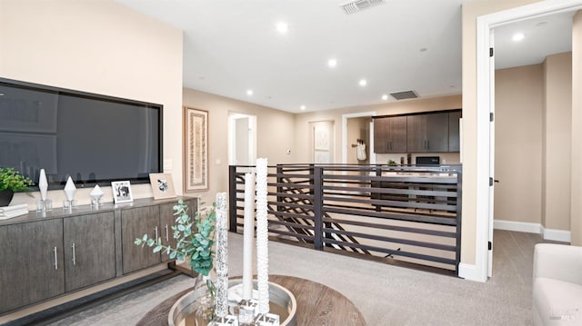 interior space featuring dark brown cabinets and light carpet