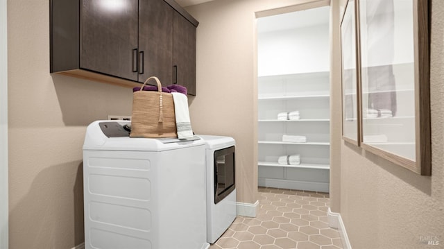 clothes washing area featuring cabinets and washer and dryer