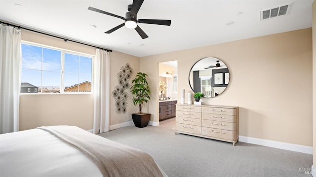 bedroom featuring ensuite bathroom, light carpet, and ceiling fan