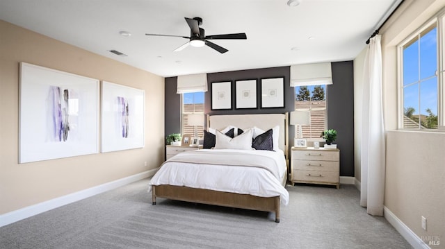 bedroom with ceiling fan, carpet flooring, and multiple windows