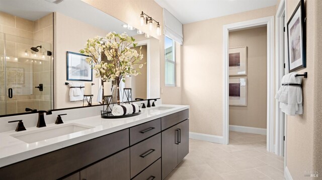 bathroom with dual vanity, walk in shower, and tile patterned floors