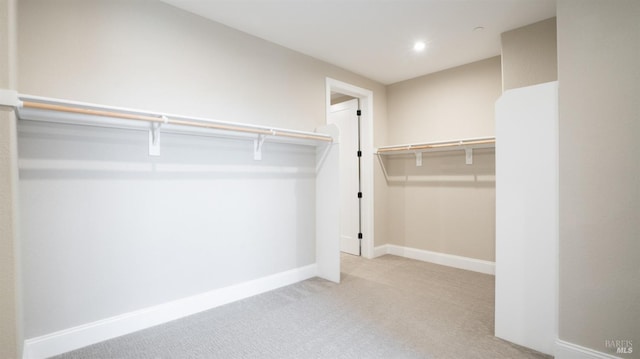 spacious closet featuring light colored carpet