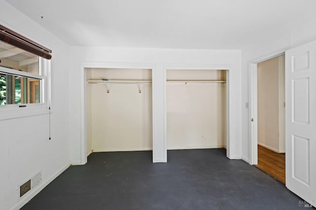 unfurnished bedroom with multiple closets and hardwood / wood-style flooring