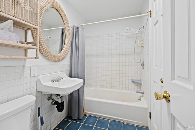 full bathroom with toilet, tile walls, tile patterned floors, shower / tub combo, and sink