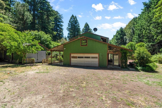 view of front facade with a garage and an outbuilding