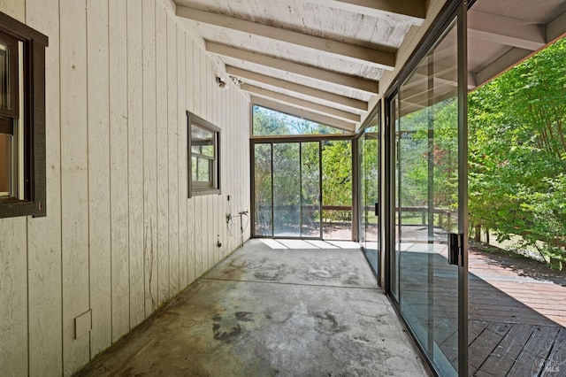 unfurnished sunroom with lofted ceiling with beams