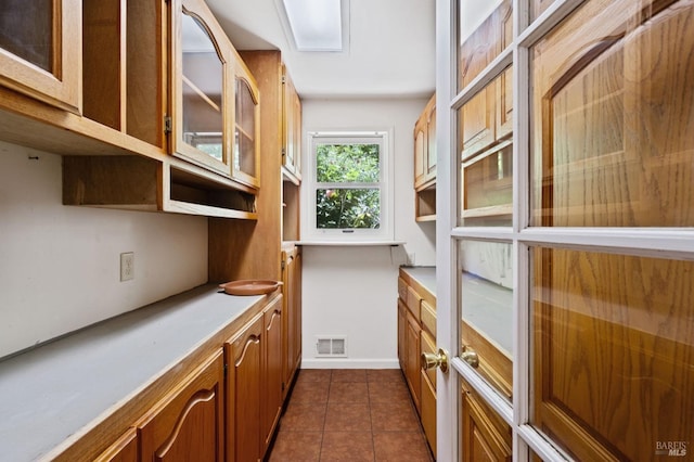 18751 Appian Way, Navarro, CA 95463 - kitchen with glass insert cabinets, dark tile patterned flooring, brown cabinetry, and light countertops