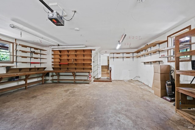 garage with a garage door opener and a workshop area