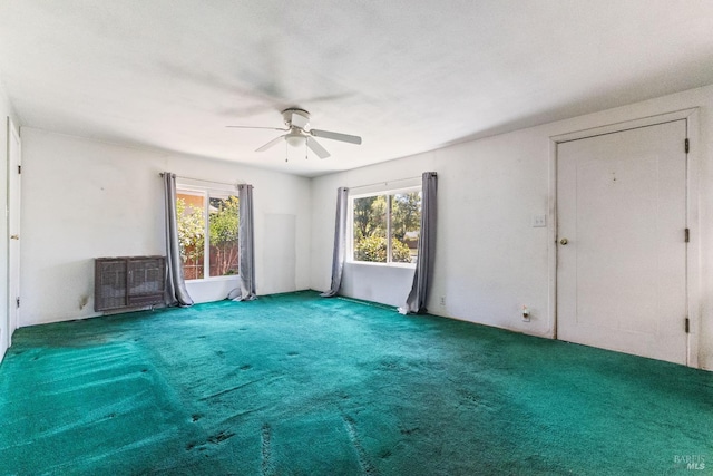carpeted spare room with a ceiling fan and a healthy amount of sunlight