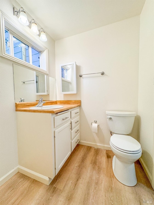 bathroom featuring hardwood / wood-style floors, toilet, and vanity