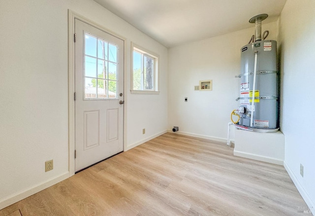clothes washing area with laundry area, hookup for an electric dryer, washer hookup, light wood-type flooring, and secured water heater