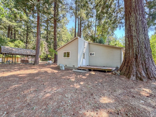 rear view of property featuring a deck and crawl space