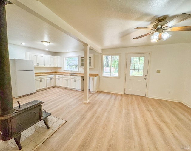 living room featuring sink, ceiling fan, light hardwood / wood-style flooring, and a textured ceiling