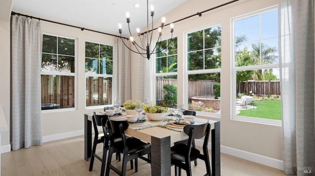 dining space with light hardwood / wood-style flooring and an inviting chandelier