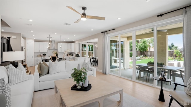 living room featuring ceiling fan and light hardwood / wood-style floors