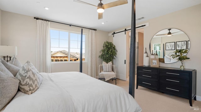 bedroom featuring light carpet, a barn door, and ceiling fan