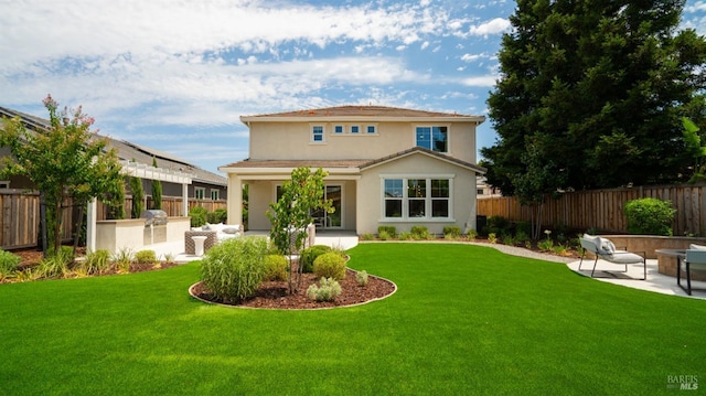 back of property with a lawn, area for grilling, and a patio area