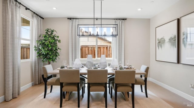 dining space featuring light hardwood / wood-style flooring and a notable chandelier