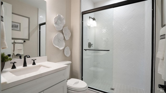 bathroom with vanity, toilet, and a shower with door