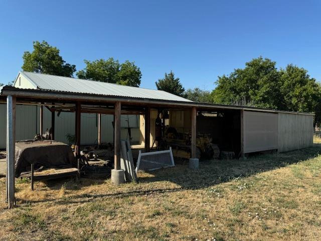 back of house featuring an outdoor structure and a lawn