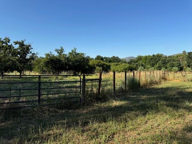 view of yard featuring fence and a rural view